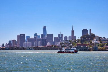 San Francisco Körfezi 'ndeki dalgalı sularda şehir merkezinde gökdelenleri olan çift katlı tur teknesinin görüntüsü
