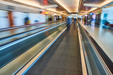 Görüntü bulanık çevre ve havaalanındaki insanlar ile odak içinde yürüyüş yolu