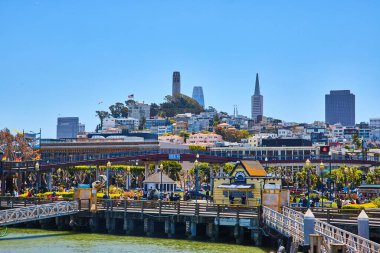 39. rıhtımın yakınındaki işlek kıyı şeridinin görüntüsü Coit Tower ile uzak tepede.