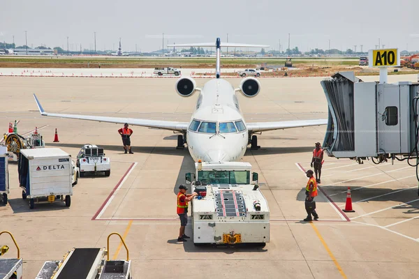 当地面车辆准备移动飞机时 员工站在飞机周围的图像 — 图库照片