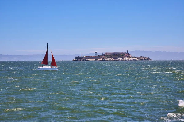 Zdjęcie Czerwonej Żaglówki Pływającej Wzburzonych Wodach Kierunku Wyspy Alcatraz — Zdjęcie stockowe