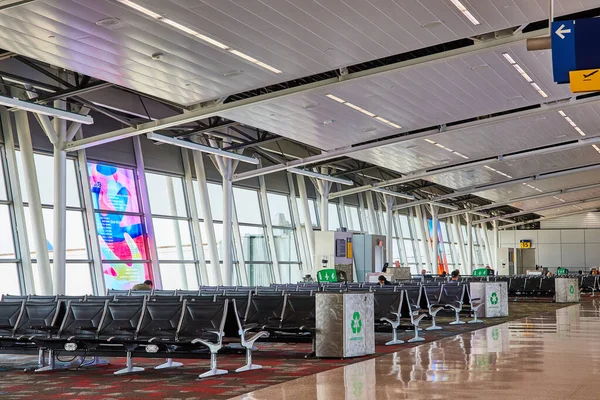 İki soyut pencere sanat eseri ve geri dönüşüm kutusuna sahip havalimanı terminali resmi