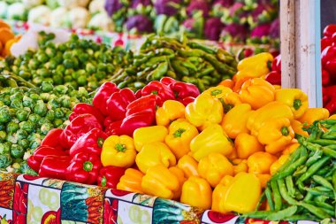 Kırmızı ve sarı dolmalık biber resmi ve masalardaki diğer sebzeler