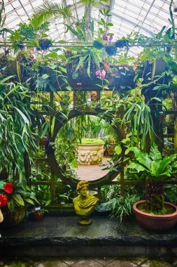 Ay Kapısı 'nın etrafında bitkiler ve heykeller olan ve bitkilerle süslü bir çömleğe açılan görüntüsü.