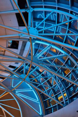 Neon mavi ışıklarının görüntüsü eğri tavanda pencereli birden fazla beyaz metal kirişi aydınlatıyor