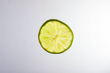 Beyaz arkaplanda yeşil kireç dilimi resmi