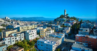 Telegraph Hill 'deki Coit Kulesi' nin görüntüsü. Uzak San Francisco Körfezi 'ndeki yüksek apartmanların arkasında.