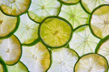 Üst üste binen yeşil limon dilimlerinin görüntüsü arka planda limon varlığından oluşan bir duvar oluşturdu