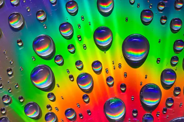 金属表面と水滴の背景資産の色の鮮やかな虹のイメージ — ストック写真