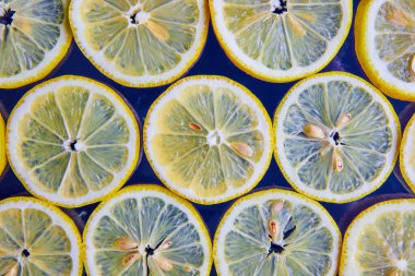 Lacivert arka planda tohumlu limon dilimlerinin ötesine bak