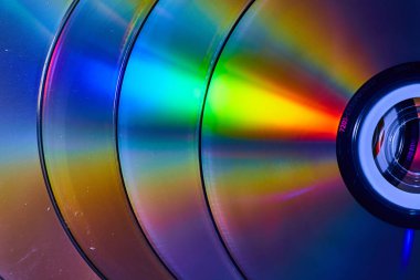 Yüzeyinde yansıtıcı gökkuşağı patlamaları olan dört gümüş CD 'den oluşan soyut yığın