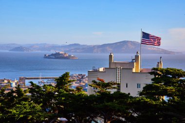 Açık Amerikan Bayrağının akşam saatlerinde Alcatraz Adası 'na bakarken rüzgarda dalgalanan görüntüsü