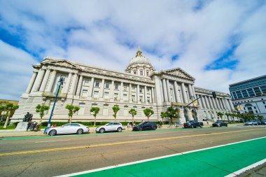 San Francisco Belediye Binası 'nın sokak boyunca park etmiş arabalarla geniş bir görüntüsü.