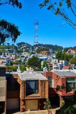 Tepedeki büyük mahalle, mavi gökyüzünde Sutro Kulesi 'ne çıkıyor.