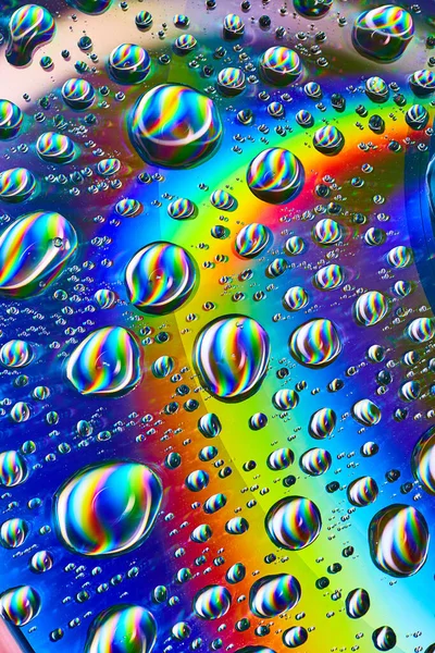サイケデリックなバックグラウンド資産の宇宙虹の土星リングに銀色の水が滴るイメージ — ストック写真
