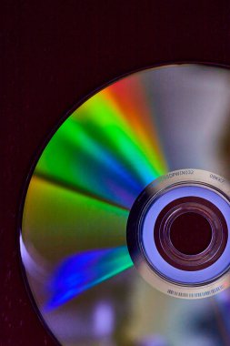 Koyu arkaplan üzerinde gökkuşağı renkli ışık patlaması olan gümüş CD 'nin görüntüsü
