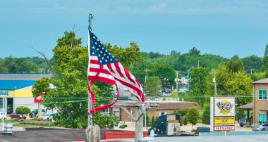 Hasarlı Amerikan bayrağının fırtınalı mavi gökyüzünde dalgalanan görüntüsü