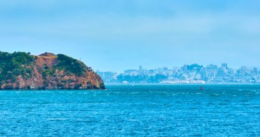 San Francisco körfezi boyunca, yüksek uçurum ve uzak San Francisco şehrinde evi olan havadan dalgalı suyun görüntüsü.