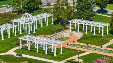 Gökyüzü Lakeside Parkı pergola 'nın görüntüsü ve havuzların yanındaki bank ve çiçeklerle bahçe alanı