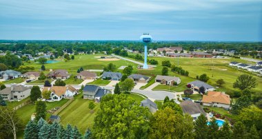 Kırsal bölgedeki yeşil hava sahalarının görüntüsü. Küçük mahallelerdeki evlerin arkasında Auburn su kulesi var.