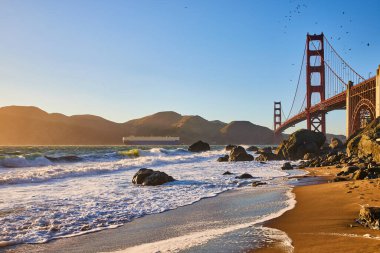 Sahilden Golden Gate Köprüsü ile çekilen sular kıyıya vuran büyük dalganın görüntüsü