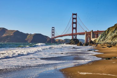 Sandy Beach 'in görüntüsü. Golden Gate Köprüsü' ne doğru sörf yapan insanlar.