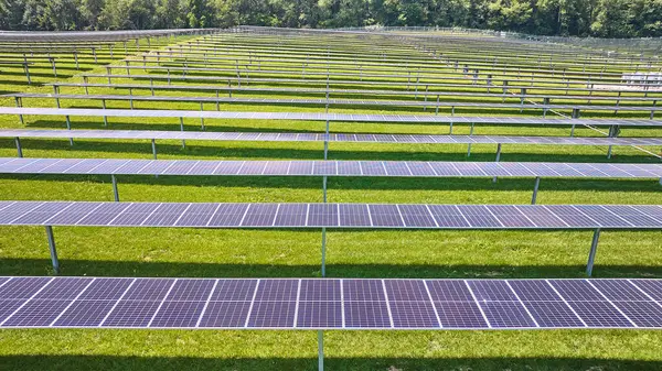 Image of Rows of solar panels in solar farm on sunny day aerial