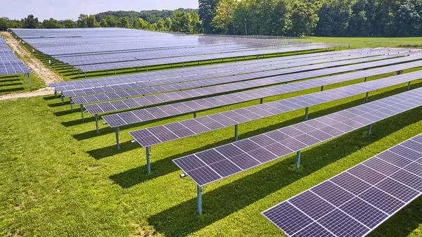 Image of Horizontal rows of solar panels on farm on sunny summer day in Midwest aerial