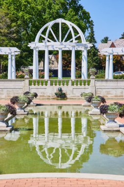 Taştan saksılarla dolu su havuzu, pergola ve çardaklı mükemmel bir açık hava düğün noktası.