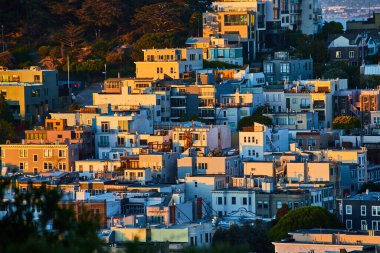 Kaliforniya 'da günbatımında tepeden yükselen apartman ve dairelerin altın ışığı görüntüsü