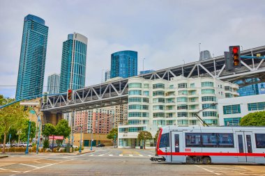 Temiz Hava Aracı 'nın beyaz bina ve gökdelenli demiryolu köprüsü ile kesiştiği görüntü