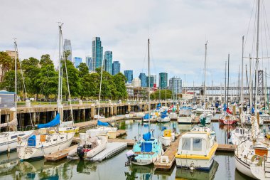 Uzak şehir gökdelenleriyle dolu bulutlu bir günde Güney Sahili Limanı 'ndaki küçük ve büyük teknelerin görüntüsü
