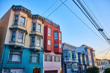 Üst ve alt katlar için farklı renklere sahip Kaliforniya evlerinin üzerinde sarı alacakaranlık ışığı