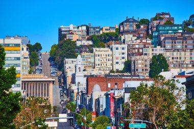 CA 'da açık mavi gökyüzünde iş ve apartman sıralarını kesen sokak görüntüsü