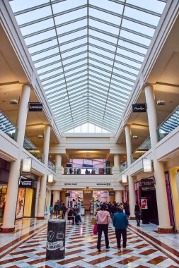 Alışveriş merkezinin içinde insanların dolaştığı sivri uçlu piramit tavan resmi