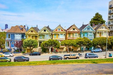 Bulutlu bir yaz gününde Boyanmış Kadınlar gibi farklı renklerde yedi evin görüntüsü