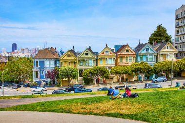 Edwardian mimarisi olan Yedi Boyalı Kadın ve çimenlerde oturan insanlar.