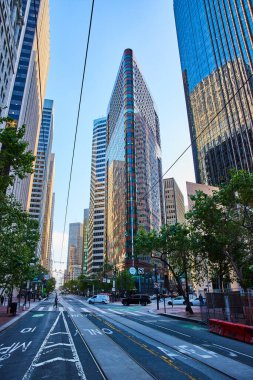 San Francisco şehir merkezindeki yansıtıcı uzun düz yolun üzerinde beliren gökdelenler.