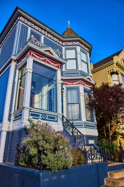 Mavinin Önü 'nün resmi Camdan girişli Boyalı Hanımlar evi ve tepemizde mavi gökyüzü.