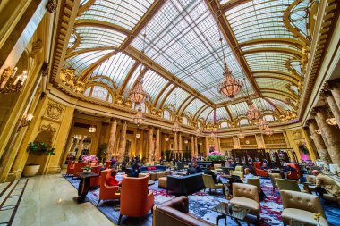 İnsanların şezlonglarda oturmuş muhteşem mavi ve mor halıların üzerinde tavanın altında avizelerle oturduklarını hayal et.