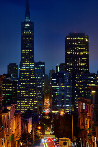 Image of Downtown San Francisco skyscrapers on foggy night with bright street cutting between buildings