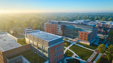 Ball State Üniversitesi sisli sabahının görüntüsü binaların üzerinde altın şafakla, Muncie, Indiana