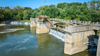 Sunny Maumee Nehir Barajı 'nın resmi. Şelalenin üzerindeki kütükler Fort Wayne' deki girdap havzasına açılıyor.