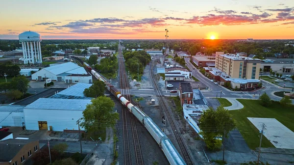 在铁路轨道上 金色的夕阳西下 酒店和水塔被火车分开的景象 — 图库照片