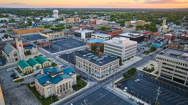 Muncie, Indiana şehir merkezindeki ofis binalarının görüntüsü. Gün batımında gökyüzü pembe.