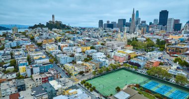 San Francisco tenis kortunun, Coit Kulesi ve gökdelenleri olan şehir havasındaki spor sahalarının görüntüsü, CA