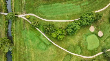 Golf sahasının iki golf arabasının üzerindeki görüntüsü. Ağaçlı, yemyeşil delikler, Crestview Golf Kulübü.
