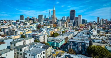 Bulutlu mavi gökyüzü gününde San Francisco gökdelenleri ve şehir havasındaki yerleşim binalarının görüntüsü, CA