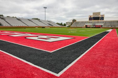 Kırmızı, beyaz ve siyah Cardinals futbol sahasının resmi, kasvetli bir günde Scheumann Stadyumu 'nda boş duruyor.