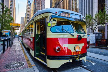 Şehir merkezindeki San Francisco caddesinde kırmızı ve krem tramvayın görüntüsü.